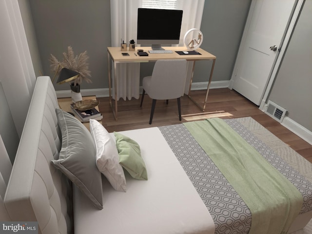 bedroom featuring visible vents, baseboards, and wood finished floors