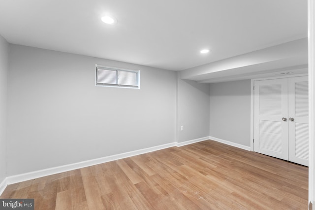 basement with baseboards, light wood-style floors, and recessed lighting