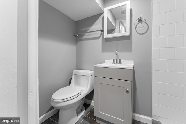 bathroom with tile patterned flooring, toilet, vanity, and baseboards