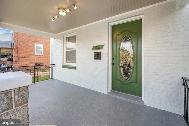 doorway to property featuring brick siding