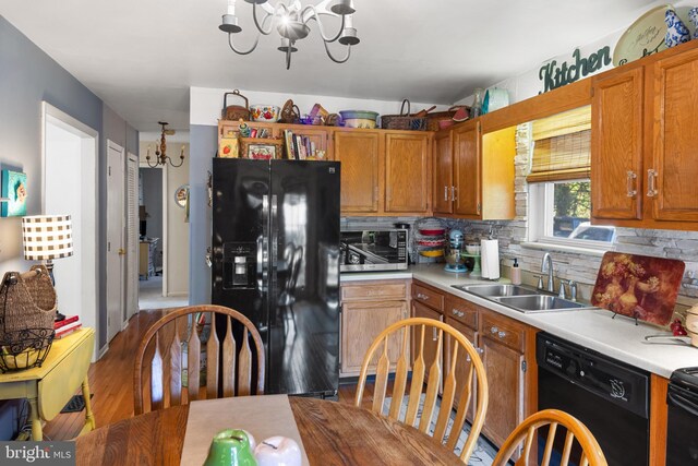 kitchen with black appliances, sink, light hardwood / wood-style flooring, and tasteful backsplash