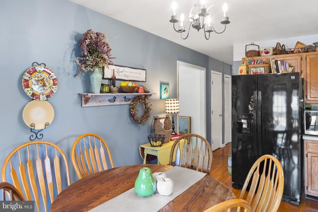 dining area featuring an inviting chandelier, sink, and light hardwood / wood-style floors