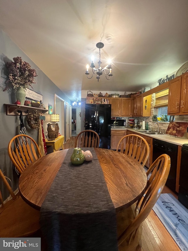 dining room featuring an inviting chandelier, sink, and light wood-type flooring