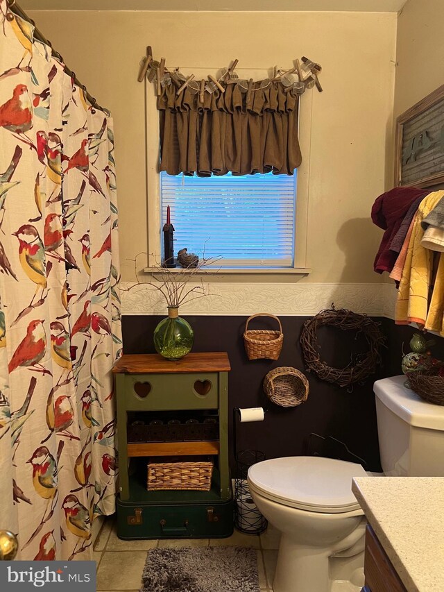 bathroom featuring vanity, tile patterned floors, and toilet