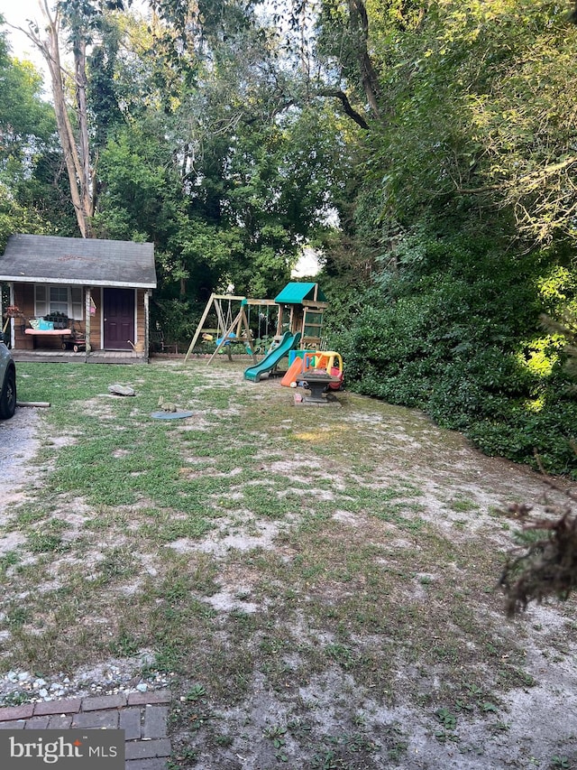 view of yard with a playground and an outbuilding