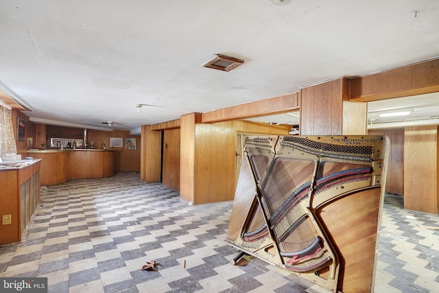 kitchen with kitchen peninsula and wooden walls