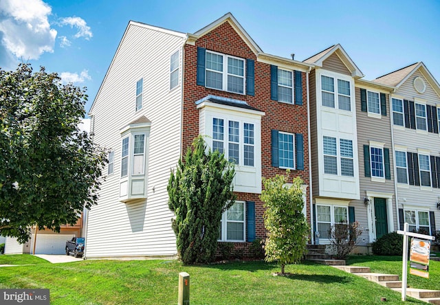 townhome / multi-family property with a garage and a front lawn