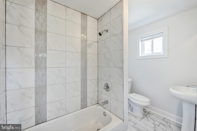 full bathroom featuring sink, toilet, and tiled shower / bath