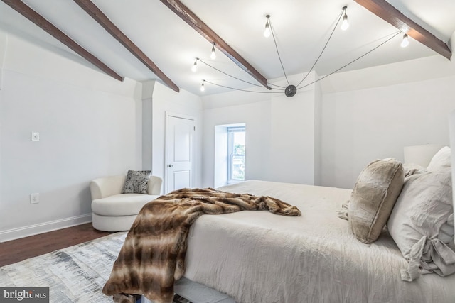 bedroom featuring hardwood / wood-style floors and beamed ceiling