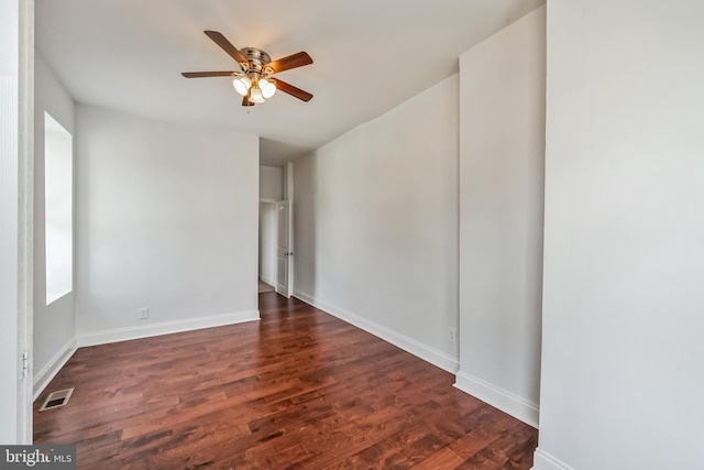 spare room with dark hardwood / wood-style flooring and ceiling fan