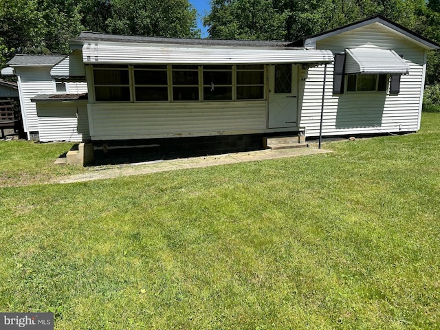 view of front of home featuring entry steps and a front yard