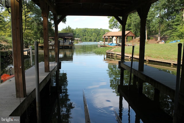 dock area with a water view and a yard