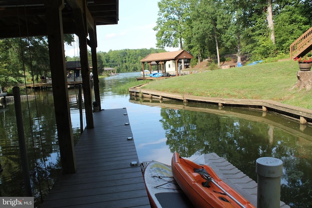 view of dock featuring a water view and a lawn