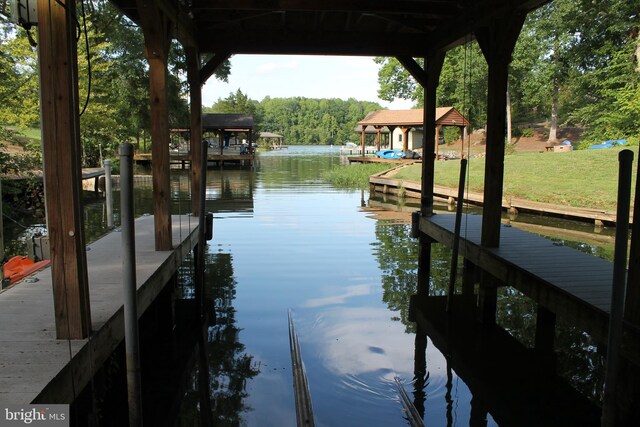 view of dock featuring a water view and a yard