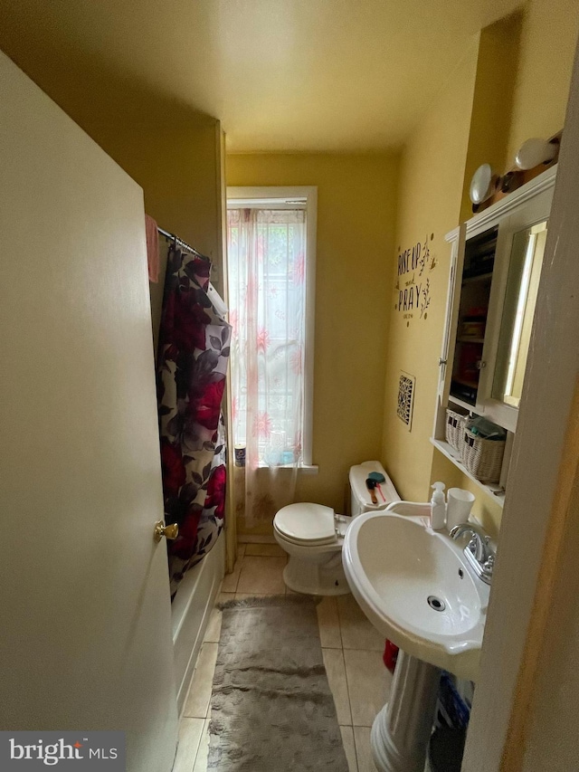 full bathroom with shower / bathtub combination with curtain, sink, tile patterned floors, and toilet