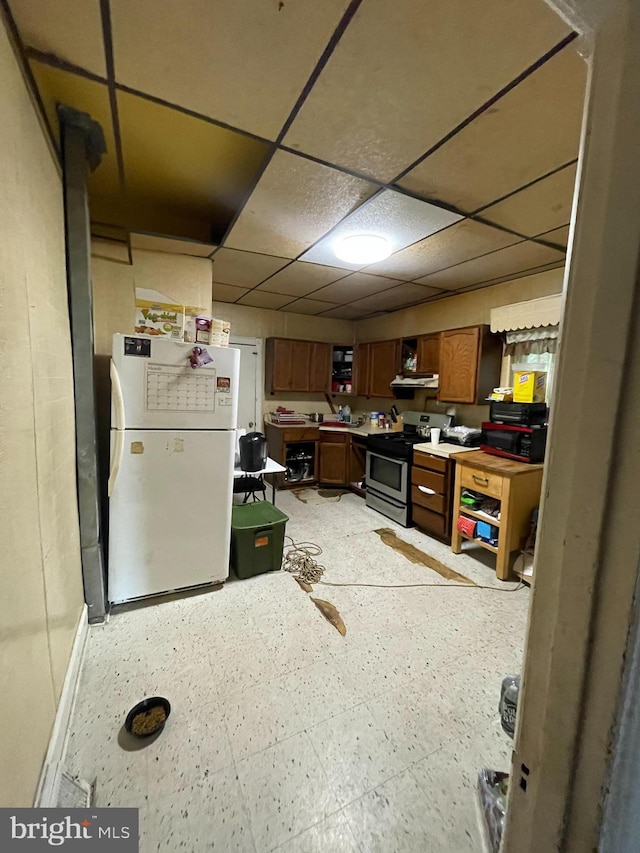 kitchen with a paneled ceiling, white fridge, and electric range