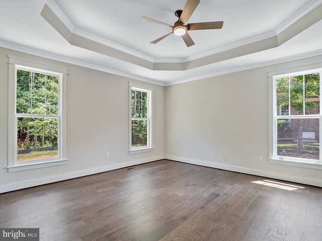 unfurnished room with crown molding, ceiling fan, dark hardwood / wood-style floors, and a tray ceiling