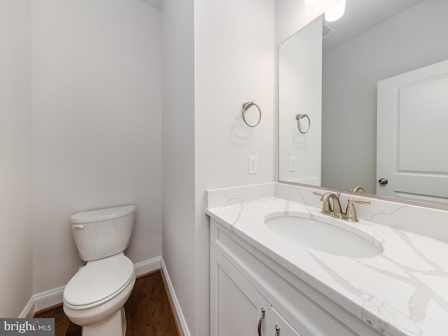 bathroom featuring toilet, hardwood / wood-style floors, and vanity