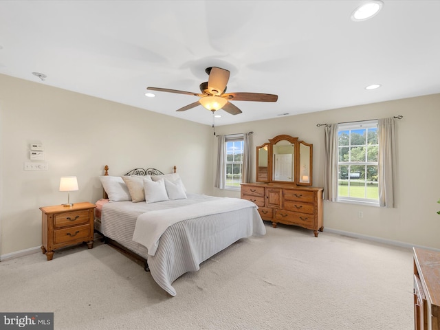 bedroom with ceiling fan and light carpet