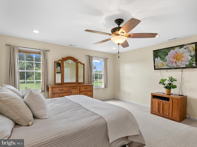 carpeted bedroom with ceiling fan and multiple windows