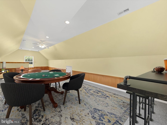 recreation room featuring ceiling fan, vaulted ceiling, and wooden walls