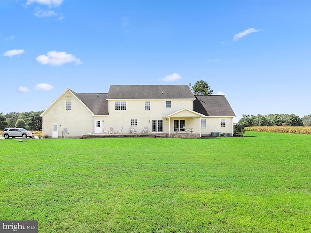 rear view of house featuring a lawn and central air condition unit