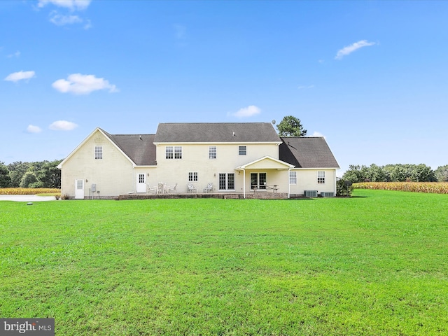 back of house featuring a yard and central AC