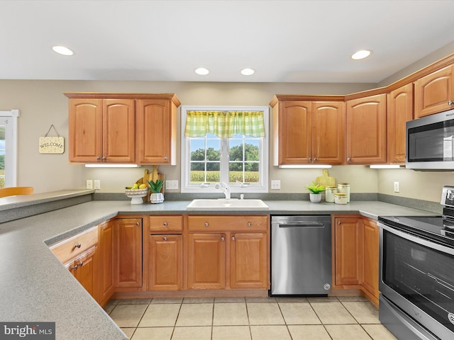 kitchen with light tile patterned floors, appliances with stainless steel finishes, and sink