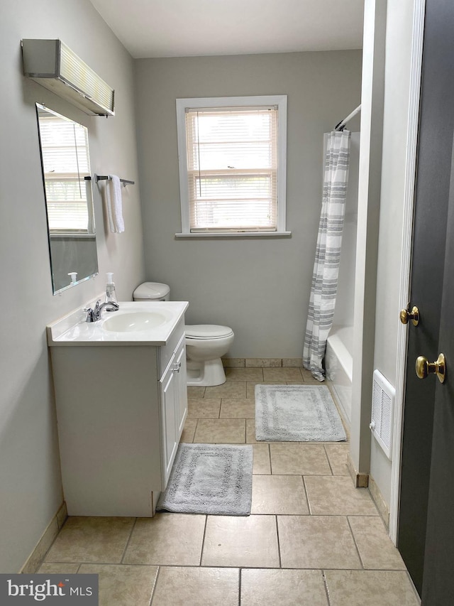 full bathroom featuring toilet, vanity, plenty of natural light, and tile patterned floors