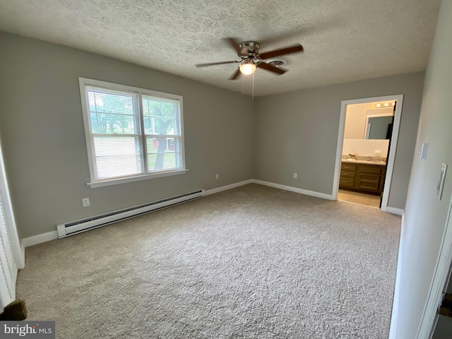 unfurnished bedroom with ceiling fan, connected bathroom, a baseboard heating unit, and a textured ceiling