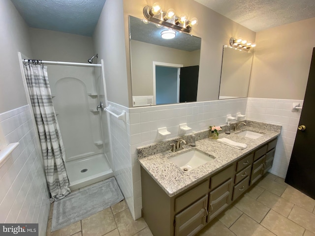 bathroom featuring tile walls, tile patterned floors, walk in shower, and a textured ceiling