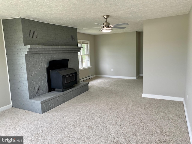 unfurnished living room featuring ceiling fan, light colored carpet, a baseboard heating unit, a wood stove, and a textured ceiling