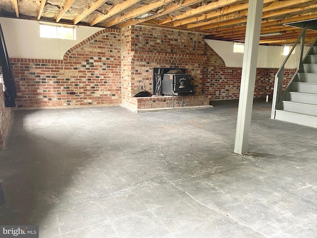 basement with brick wall and a wood stove