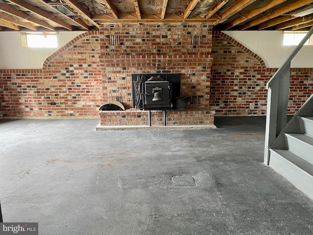 basement featuring brick wall and a wood stove