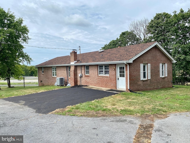 ranch-style house with a front lawn and central AC