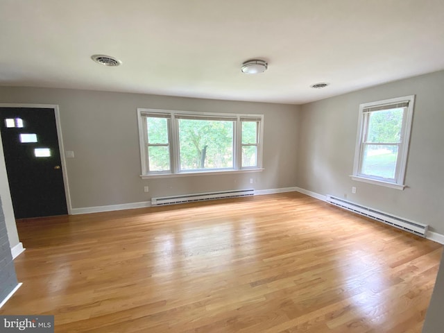 interior space featuring a baseboard heating unit and light hardwood / wood-style floors