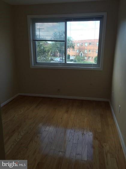 unfurnished room with wood-type flooring