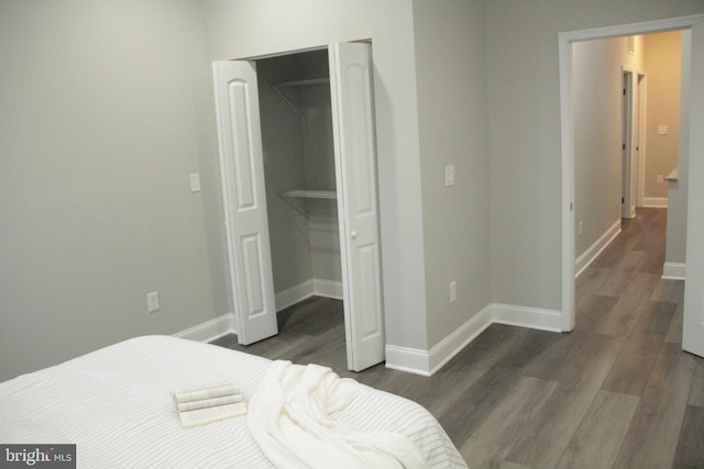 bedroom with a closet, a spacious closet, and dark hardwood / wood-style flooring