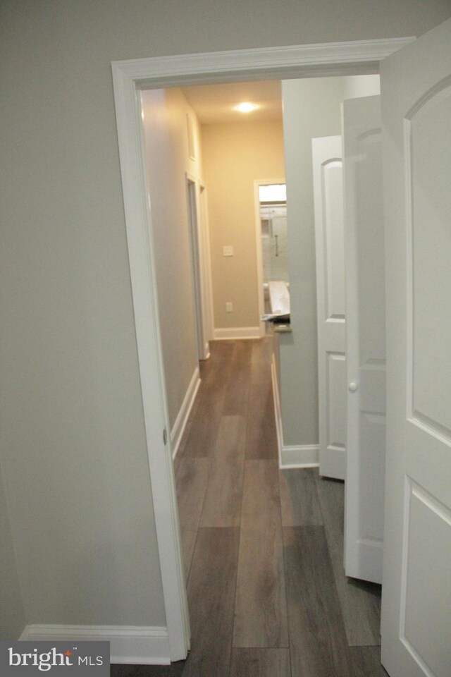 corridor with dark hardwood / wood-style flooring