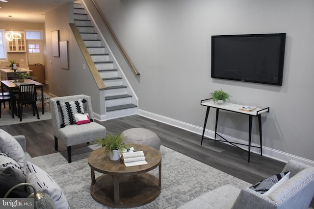 living room with dark hardwood / wood-style flooring and a chandelier