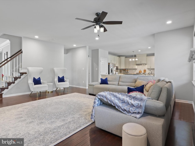 living room with dark hardwood / wood-style flooring and ceiling fan