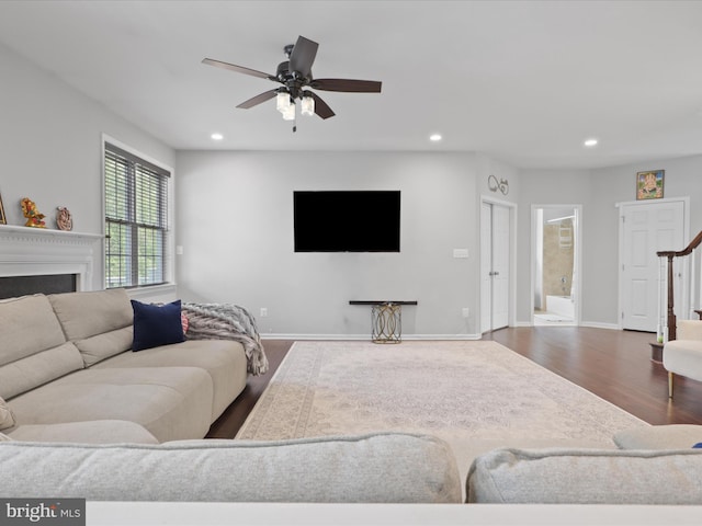 living room featuring wood-type flooring and ceiling fan