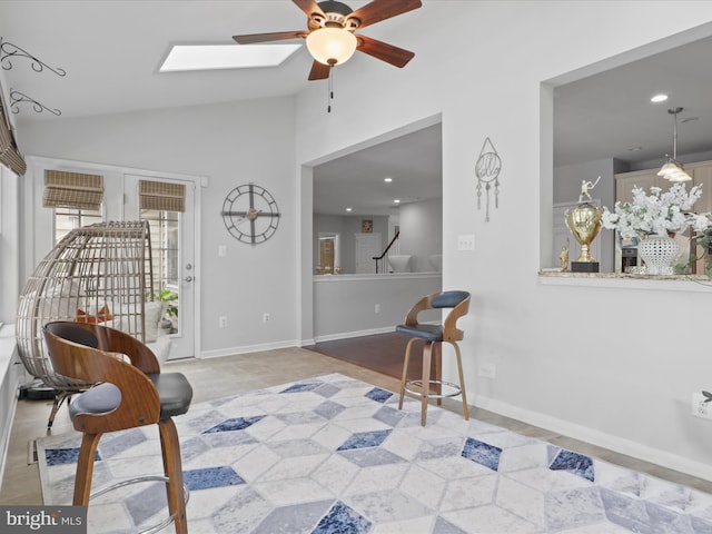 living area with lofted ceiling with skylight and ceiling fan