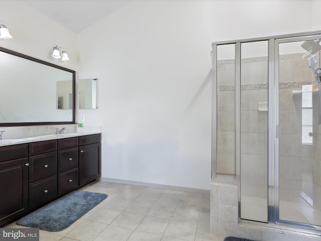 bathroom with a shower with door, vanity, and tile patterned floors