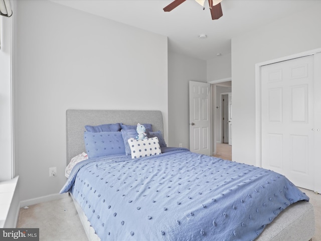 bedroom with light colored carpet, a closet, and ceiling fan