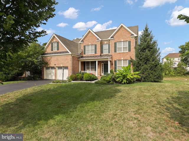 view of front of property with a garage, covered porch, and a front lawn