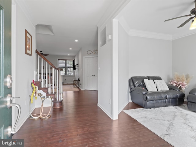 entryway with dark wood-type flooring, ceiling fan, and ornamental molding