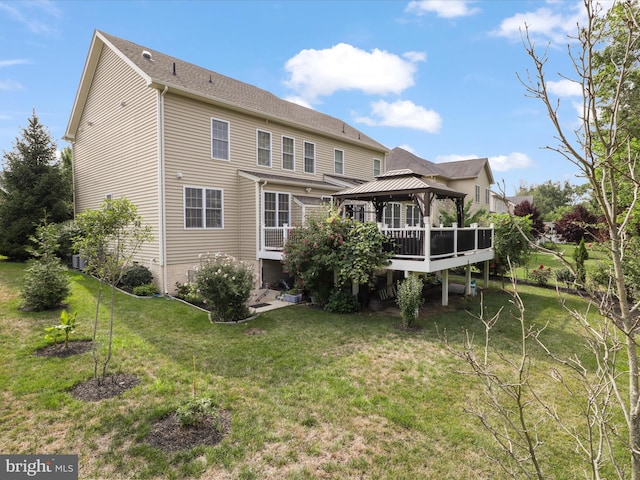 rear view of property featuring a gazebo and a lawn