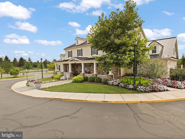 view of front of house with covered porch and a front yard