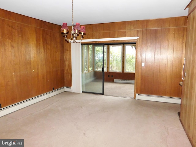 empty room featuring an inviting chandelier, wood walls, and baseboard heating